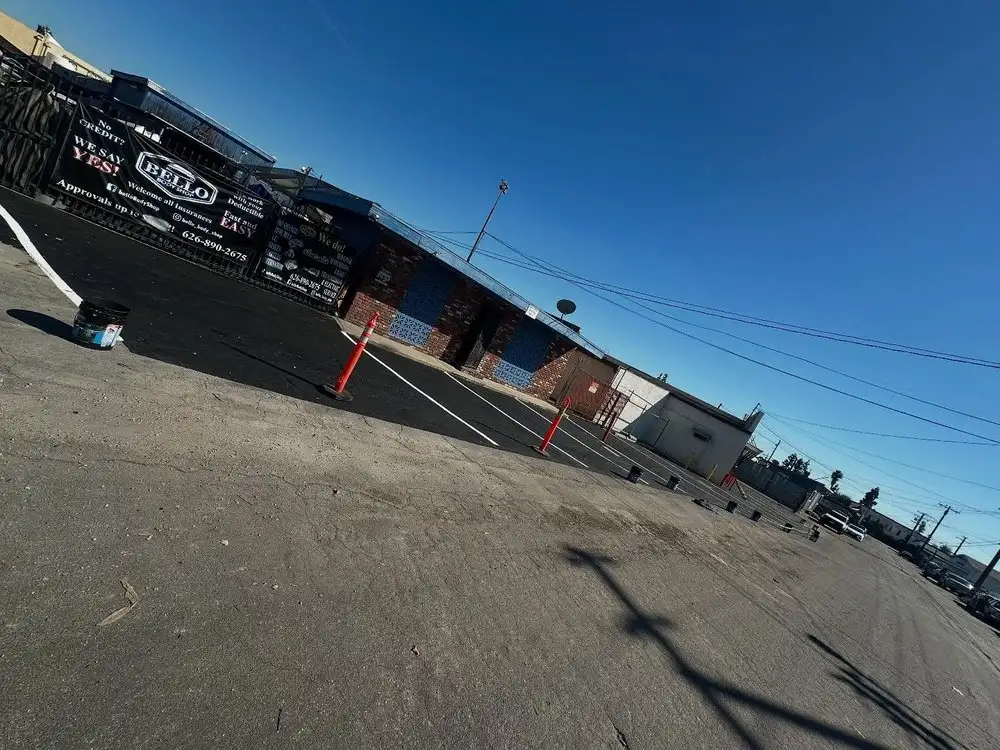 The Bello Body Shop banner and freshly paved parking lot in front of the shop